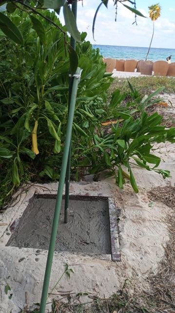 Dado de concreto recién colado para poste de red junto a la playa