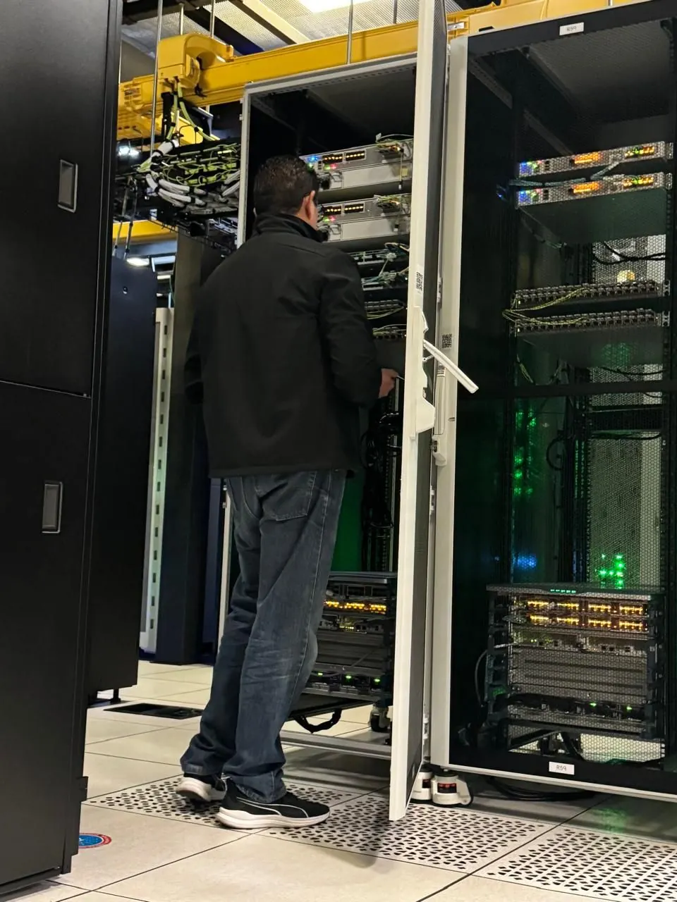 Técnico de JRP Network frente a racks en una sala de centro de datos